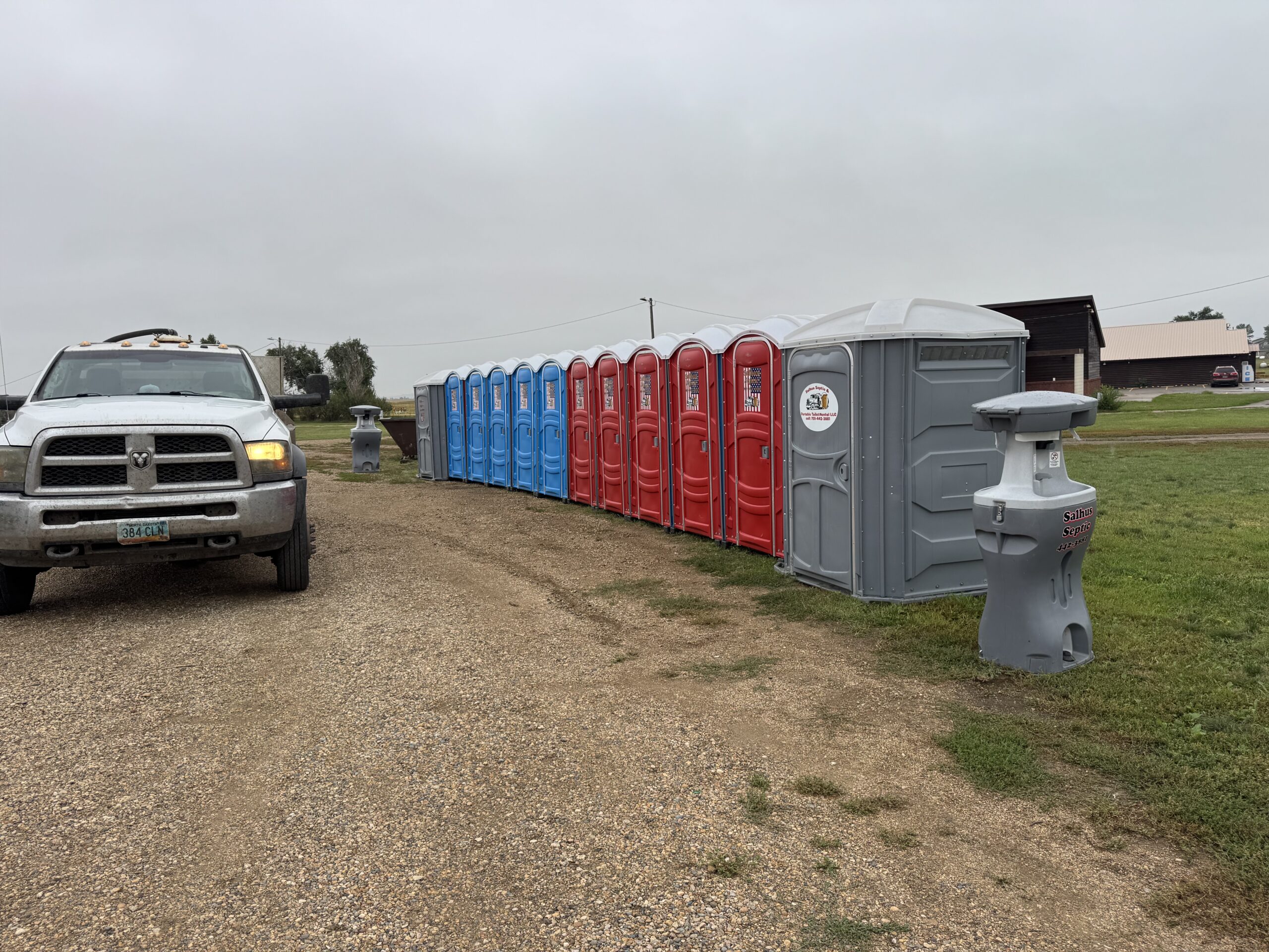Three portable toilets with a handwashing station