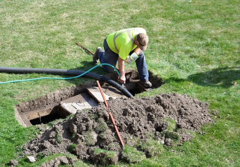 Worker servicing a septic tank through an open access point