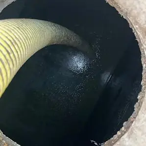 Professional septic tank pumping truck removing waste from residential septic tank