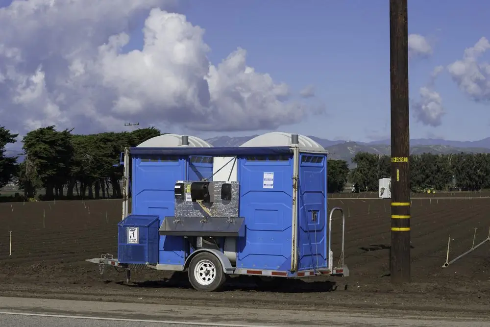 Trailer-mounted portable toilets with a handwashing sink